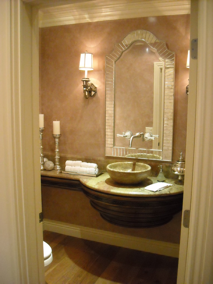 Kleine Klassische Gästetoilette mit Aufsatzwaschbecken, Marmor-Waschbecken/Waschtisch, rosa Wandfarbe und braunem Holzboden in Los Angeles