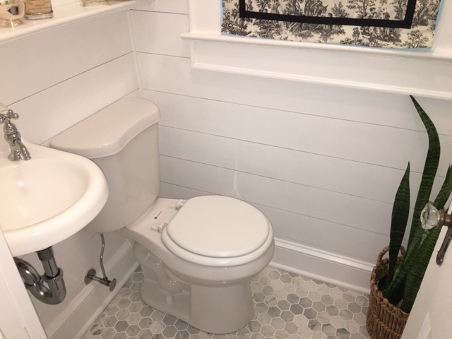 ニューヨークにある低価格の小さなトランジショナルスタイルのおしゃれなトイレ・洗面所 (ガラス扉のキャビネット、白いキャビネット、一体型トイレ	、白いタイル、大理石タイル、グレーの壁、大理石の床、壁付け型シンク、大理石の洗面台、グレーの床) の写真
