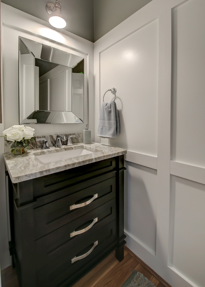 This is an example of a small classic cloakroom in Dallas with freestanding cabinets, black cabinets, grey walls, medium hardwood flooring, a submerged sink, marble worktops, brown floors and grey worktops.