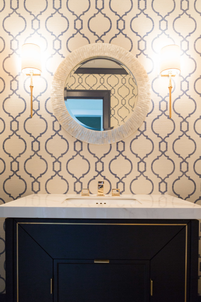 Foto di un bagno di servizio classico di medie dimensioni con consolle stile comò, ante blu, pareti multicolore, lavabo sottopiano e top in marmo