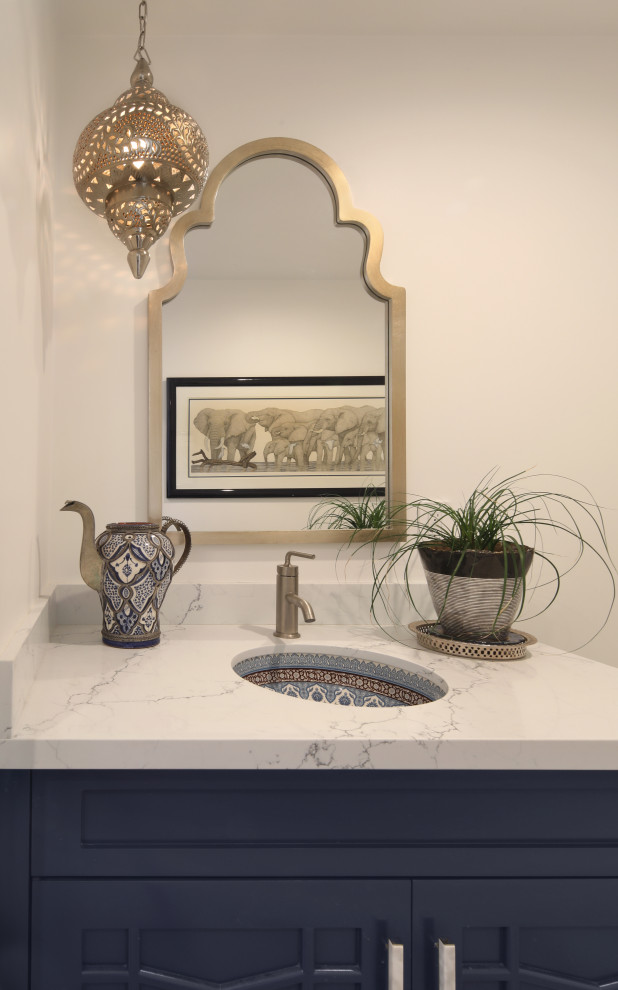 Photo of a medium sized nautical cloakroom in Orange County with raised-panel cabinets, blue cabinets, a one-piece toilet, white walls, mosaic tile flooring, a submerged sink, engineered stone worktops, blue floors and white worktops.