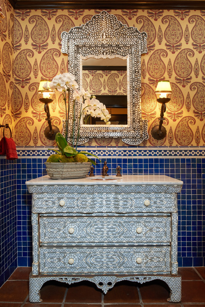 Esempio di un bagno di servizio mediterraneo di medie dimensioni con consolle stile comò, ante bianche, piastrelle blu, piastrelle in ceramica, pareti multicolore, pavimento in terracotta, lavabo sottopiano e top in marmo