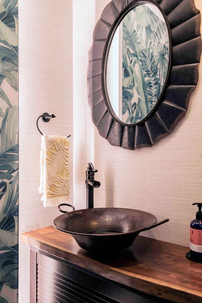 Kleine Gästetoilette mit Lamellenschränken, schwarzen Schränken, beiger Wandfarbe, Aufsatzwaschbecken, Waschtisch aus Holz, brauner Waschtischplatte und freistehendem Waschtisch in Singapur
