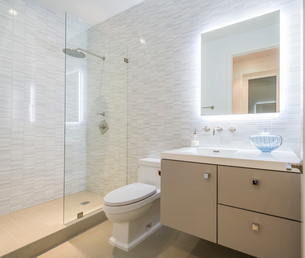 Idées déco pour une salle de bain contemporaine avec un lavabo intégré, un placard à porte plane, des portes de placard beiges, un carrelage blanc et un carrelage de pierre.