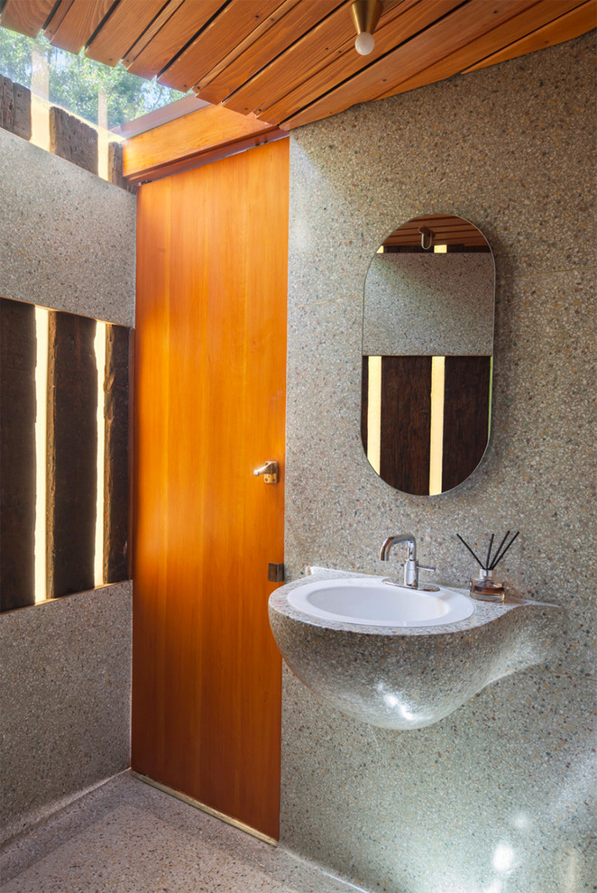 Bild på ett 60 tals toalett, med grå väggar, ett nedsänkt handfat och grått golv