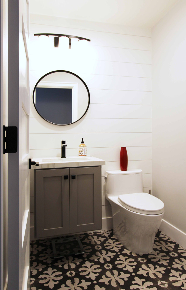Mid-sized transitional porcelain tile, black floor and shiplap wall powder room photo in Other with shaker cabinets, gray cabinets, a one-piece toilet, white walls, an undermount sink, quartz countertops, white countertops and a floating vanity