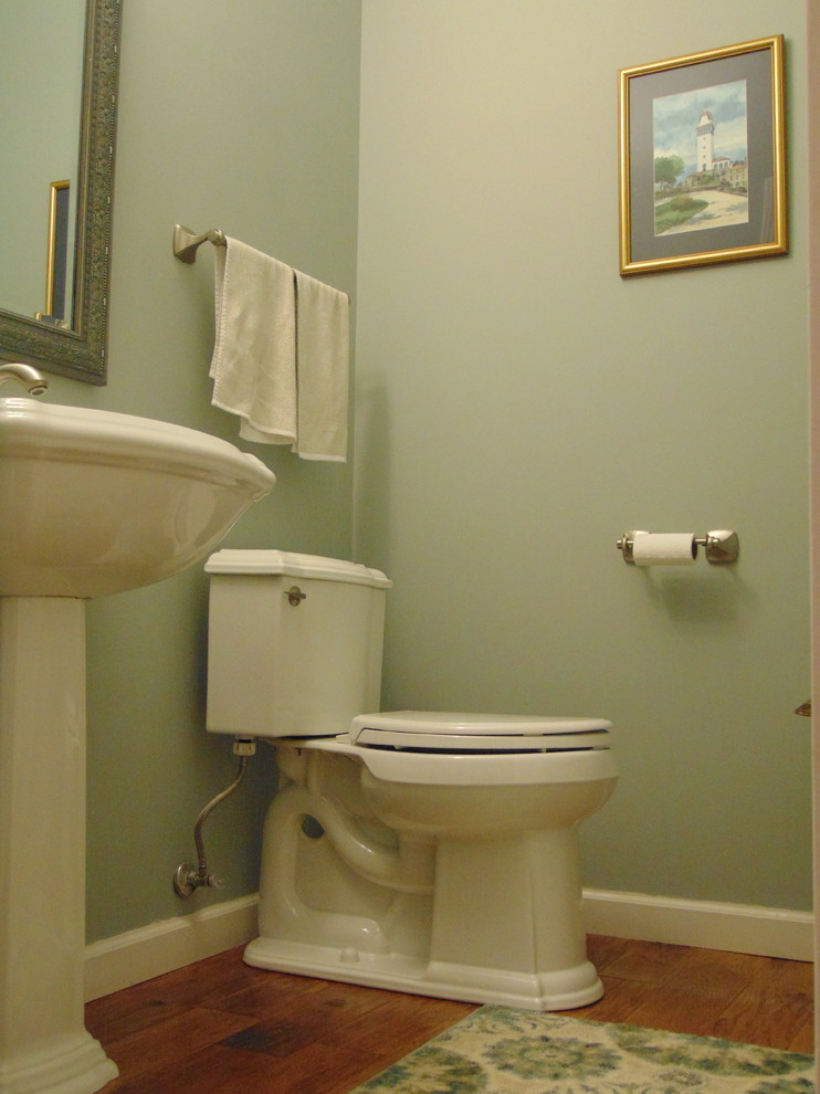 Idéer för vintage toaletter, med gröna väggar, mörkt trägolv och ett piedestal handfat