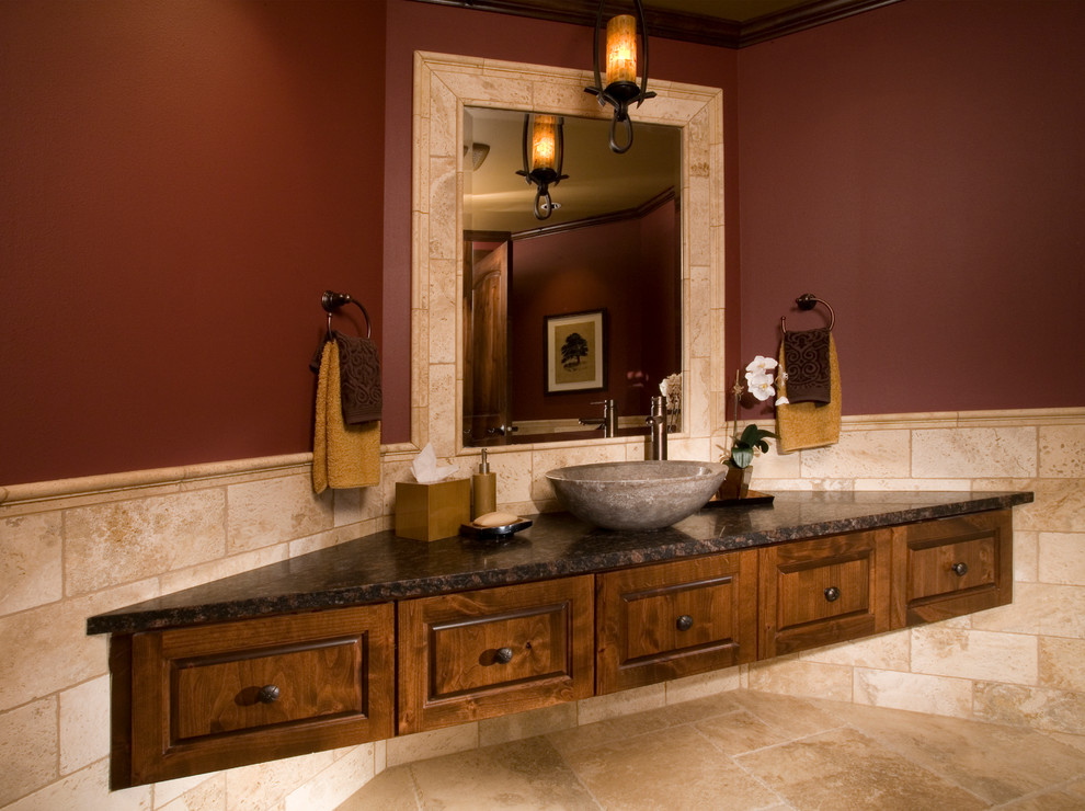 Cette photo montre un WC et toilettes chic en bois brun de taille moyenne avec une vasque, un placard avec porte à panneau encastré, un plan de toilette en marbre, un carrelage beige, des carreaux de céramique, un mur rouge et un sol en carrelage de céramique.