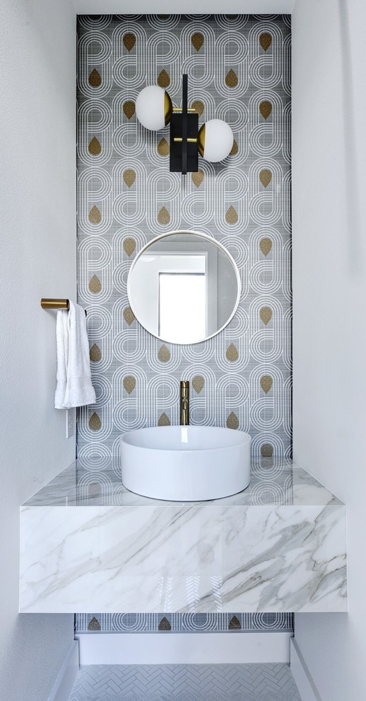 На фото: туалет в скандинавском стиле с разноцветными стенами, настольной раковиной, мраморной столешницей, белым полом и акцентной стеной с