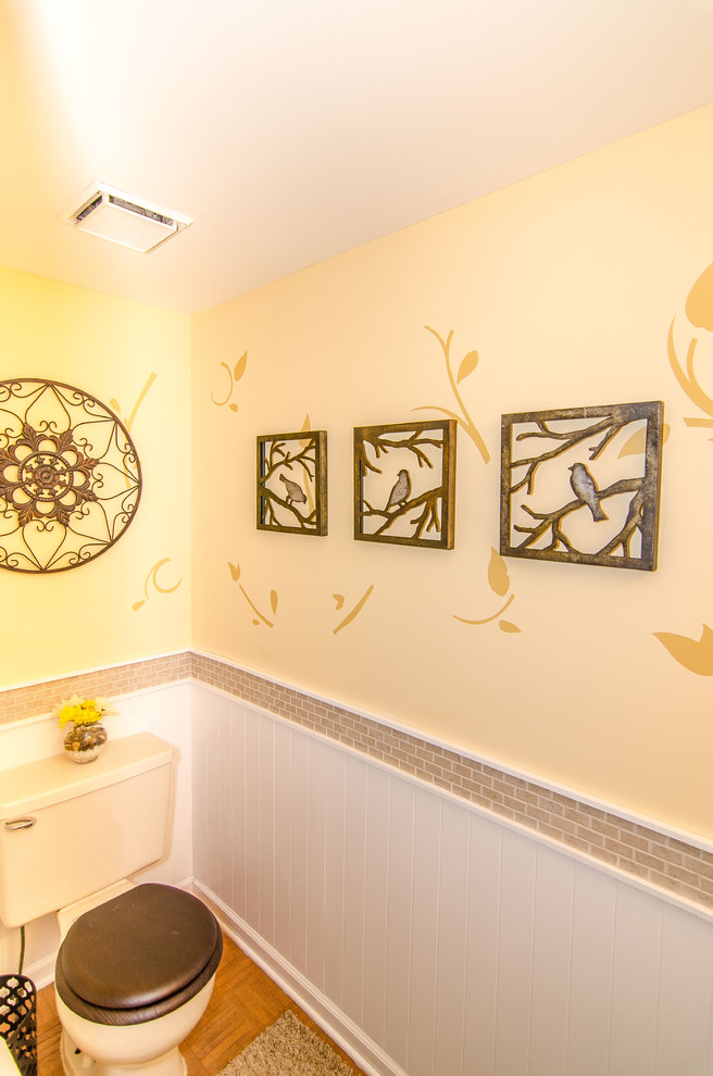 Mittelgroße Klassische Gästetoilette mit Einbauwaschbecken, Toilette mit Aufsatzspülkasten, beigen Fliesen, Keramikfliesen, gelber Wandfarbe und braunem Holzboden in Philadelphia
