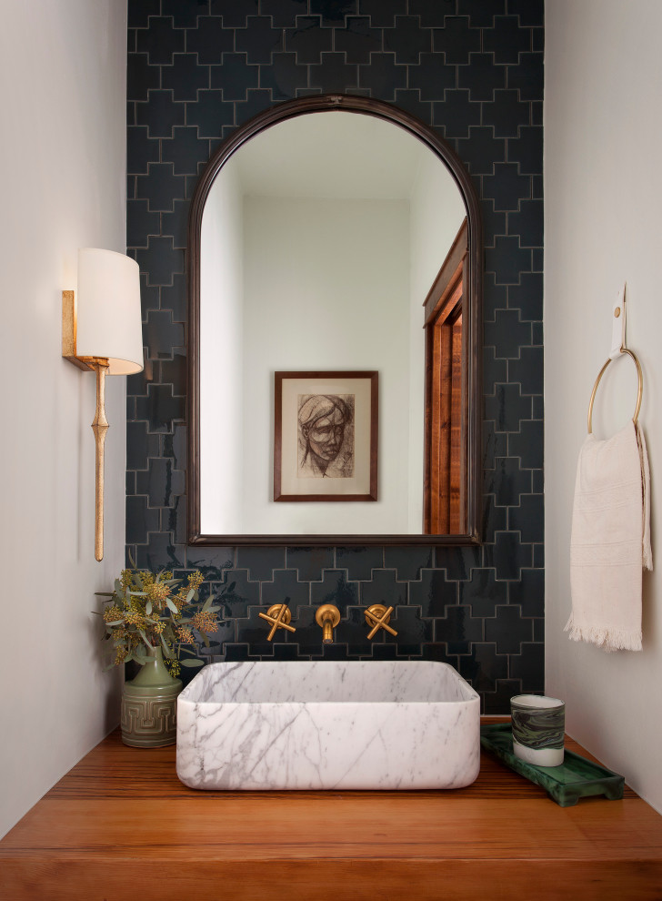 На фото: туалет среднего размера в средиземноморском стиле с накладной раковиной, черной плиткой, керамогранитной плиткой, белыми стенами, столешницей из дерева, коричневой столешницей и подвесной тумбой