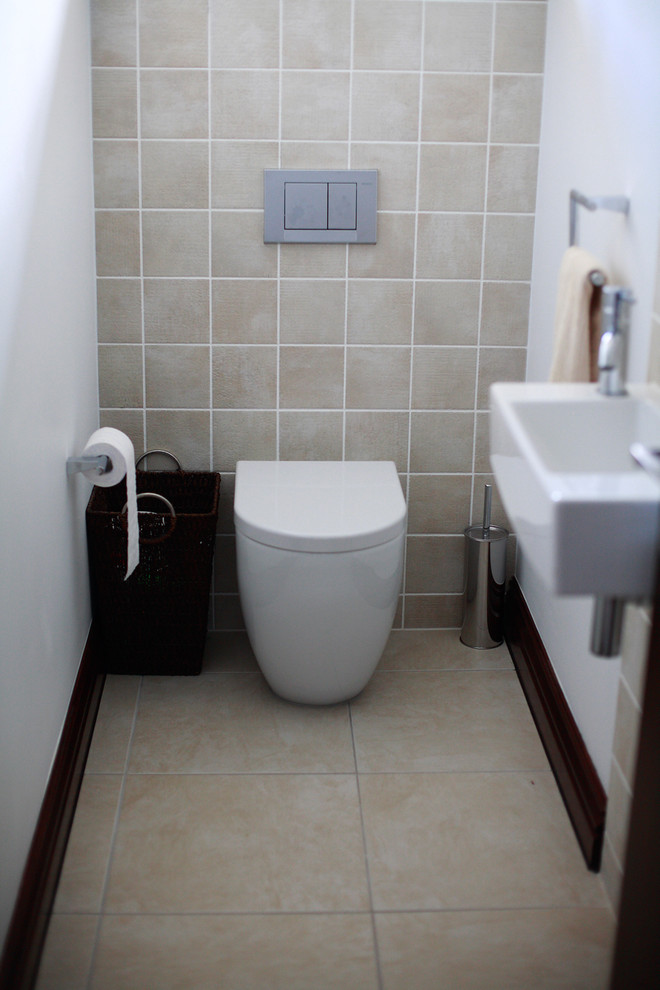 Exemple d'un petit WC et toilettes tendance avec un carrelage beige, un mur beige, un sol en travertin et un sol beige.
