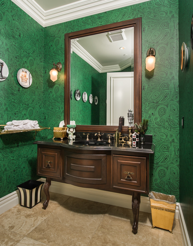 Mediterrane Gästetoilette mit verzierten Schränken, dunklen Holzschränken, grüner Wandfarbe und schwarzer Waschtischplatte in Los Angeles