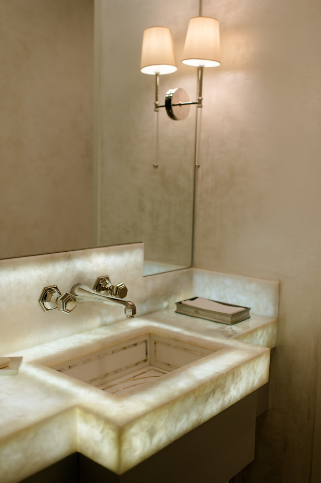 Пример оригинального дизайна: туалет среднего размера в стиле неоклассика (современная классика) с столешницей из оникса, бежевыми стенами, врезной раковиной и белой столешницей