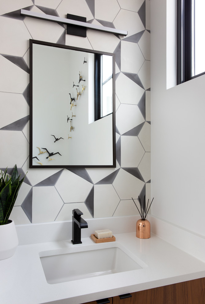 Photo of a small contemporary cloakroom in Austin with flat-panel cabinets, brown cabinets, a one-piece toilet, black and white tiles, cement tiles, white walls, cement flooring, a submerged sink, engineered stone worktops and white worktops.