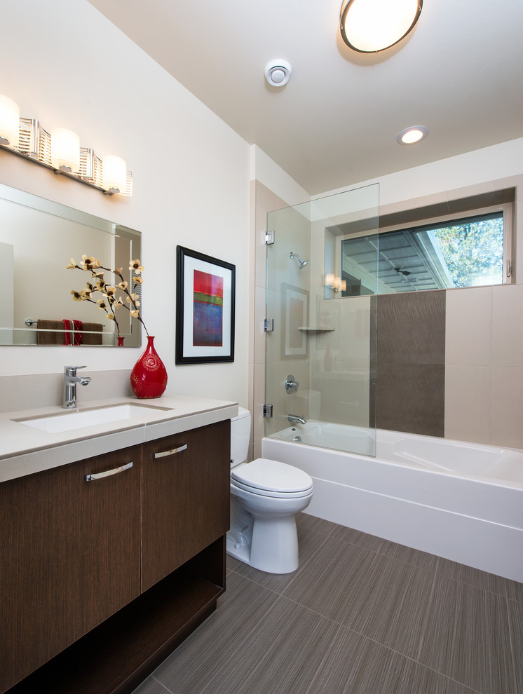 Exempel på ett mellanstort modernt badrum, med ett undermonterad handfat, släta luckor, skåp i mörkt trä, en toalettstol med separat cisternkåpa, grå kakel, porslinskakel, vita väggar och klinkergolv i porslin