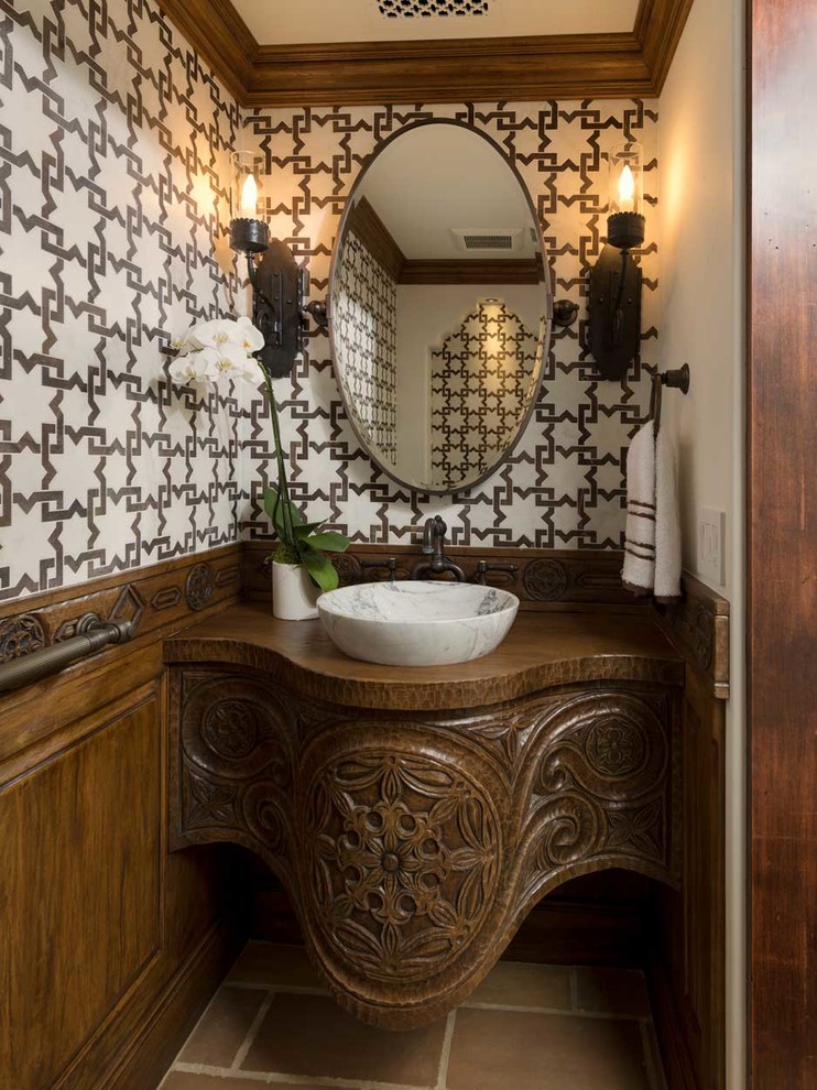 Свежая идея для дизайна: туалет в средиземноморском стиле с фасадами цвета дерева среднего тона, разноцветными стенами, настольной раковиной, столешницей из дерева, коричневым полом и коричневой столешницей - отличное фото интерьера