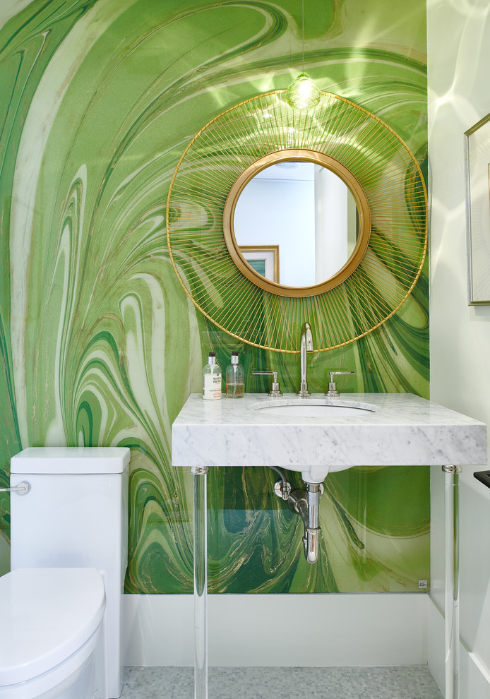 Réalisation d'un WC et toilettes design avec un mur vert, un lavabo encastré et un plan de toilette en marbre.