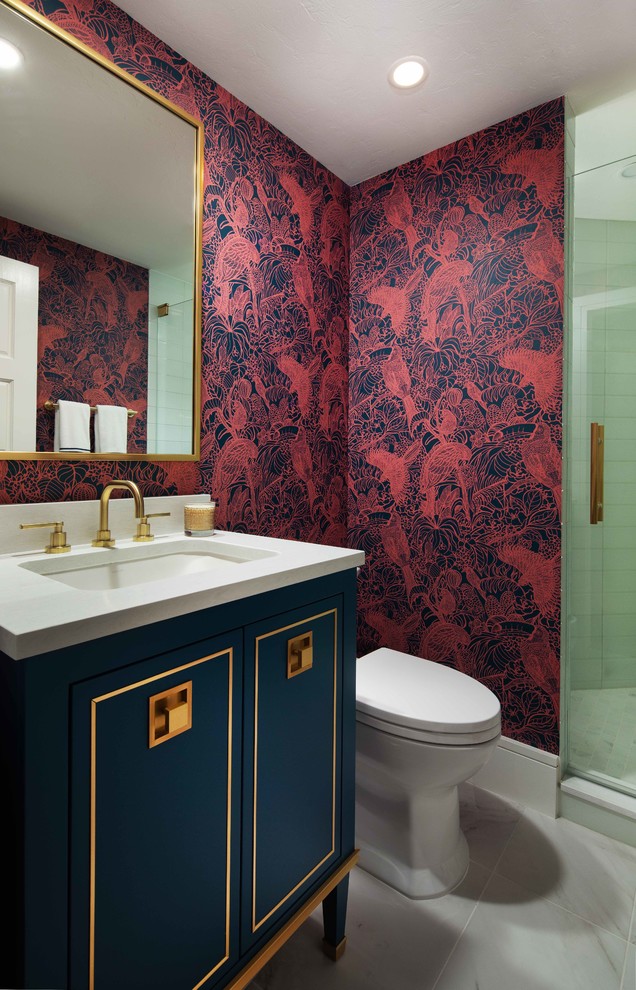 Inspiration pour un WC et toilettes traditionnel avec un placard en trompe-l'oeil, des portes de placard bleues, un mur rouge, un lavabo encastré, un sol gris et un plan de toilette blanc.