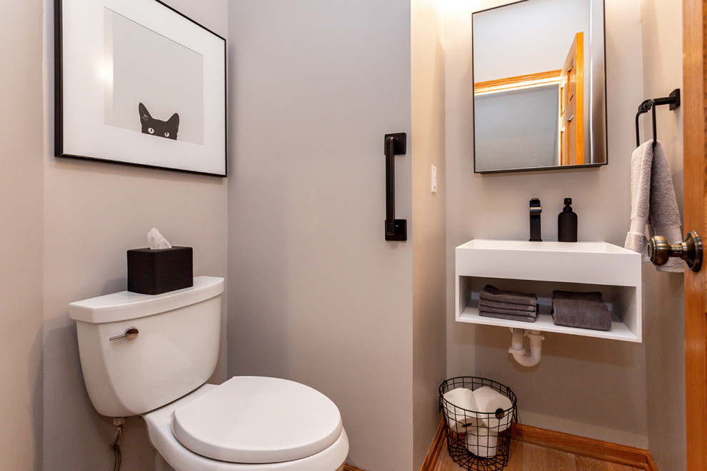 Kleine Moderne Gästetoilette mit Wandtoilette mit Spülkasten, grauer Wandfarbe, hellem Holzboden, Wandwaschbecken und beigem Boden in Sonstige