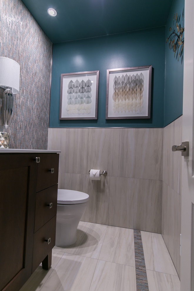 Mid-sized trendy multicolored tile and mosaic tile porcelain tile and gray floor powder room photo in San Francisco with furniture-like cabinets, dark wood cabinets, a two-piece toilet, blue walls, an integrated sink, quartz countertops and white countertops