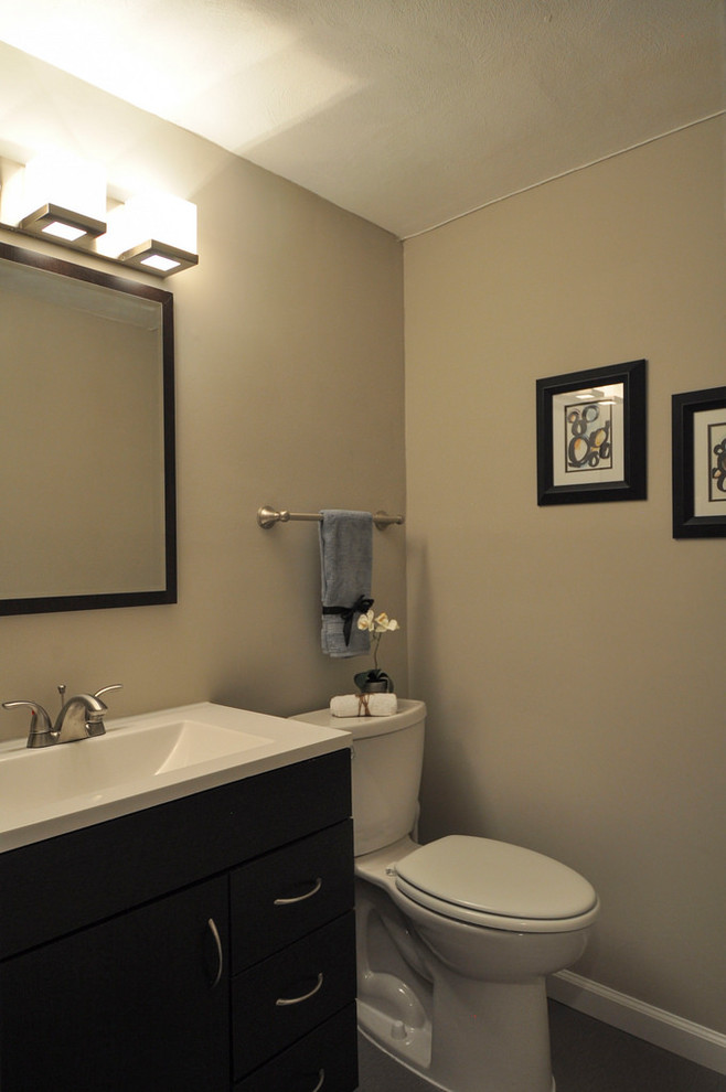 Mid-sized 1960s vinyl floor and gray floor powder room photo in St Louis with gray walls, an integrated sink, white countertops, flat-panel cabinets and dark wood cabinets
