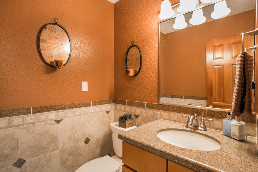 Große Moderne Gästetoilette mit Schrankfronten im Shaker-Stil, hellen Holzschränken, Wandtoilette mit Spülkasten, beigen Fliesen, Keramikfliesen, oranger Wandfarbe, Keramikboden, Unterbauwaschbecken und Granit-Waschbecken/Waschtisch in Albuquerque