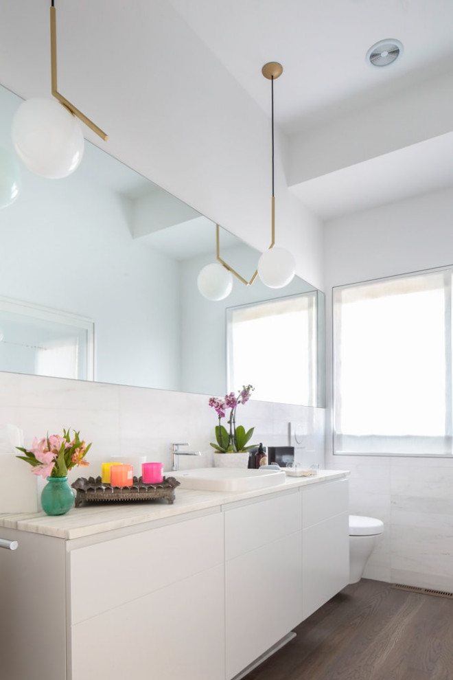 Mittelgroße Moderne Gästetoilette mit flächenbündigen Schrankfronten, Toilette mit Aufsatzspülkasten, braunem Holzboden, Unterbauwaschbecken und eingebautem Waschtisch in New York