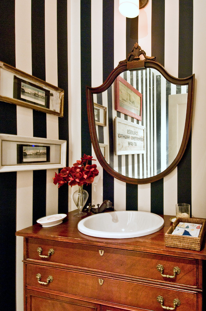 Klassische Gästetoilette mit verzierten Schränken, hellbraunen Holzschränken, Einbauwaschbecken und bunten Wänden in New York