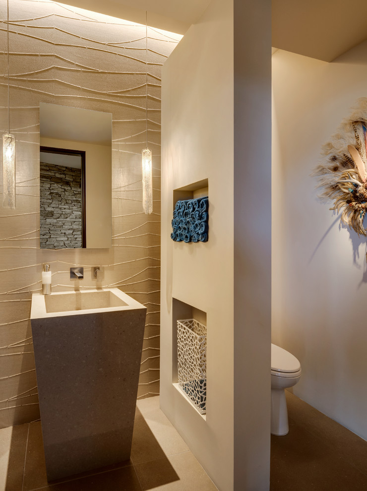 Modern inredning av ett mellanstort toalett, med en toalettstol med hel cisternkåpa, vita väggar, klinkergolv i porslin, ett piedestal handfat och beiget golv