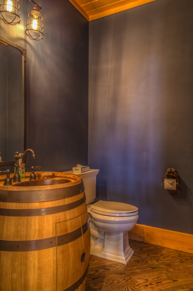 他の地域にある中くらいなサンタフェスタイルのおしゃれなトイレ・洗面所 (茶色いキャビネット、分離型トイレ、紫の壁、淡色無垢フローリング、オーバーカウンターシンク、木製洗面台、茶色い床) の写真