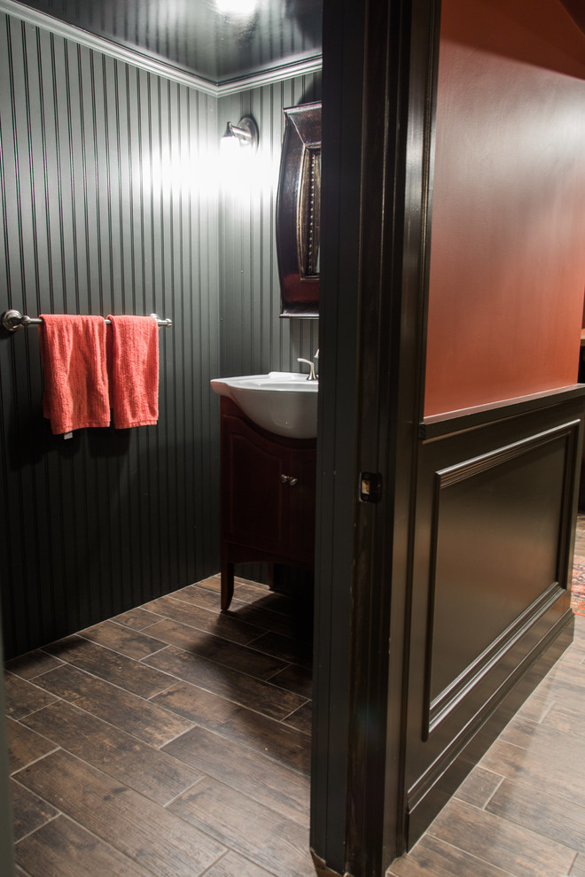 Inspiration pour un petit WC et toilettes traditionnel en bois foncé avec un placard sans porte, un mur gris, sol en stratifié, un plan vasque, un plan de toilette en surface solide et un sol marron.