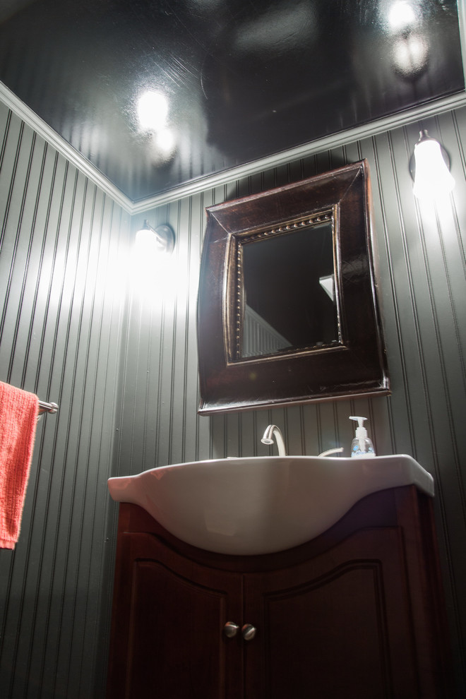 Immagine di un piccolo bagno di servizio classico con nessun'anta, ante in legno bruno, pareti grigie, pavimento in laminato, lavabo a consolle, top in superficie solida e pavimento marrone