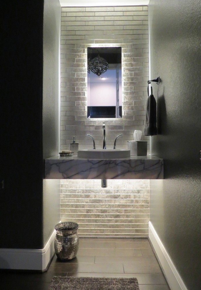 ヒューストンにある小さなコンテンポラリースタイルのおしゃれなトイレ・洗面所 (茶色い床、グレーの壁、オープンシェルフ、グレーのタイル、ガラスタイル、濃色無垢フローリング、ベッセル式洗面器、大理石の洗面台) の写真