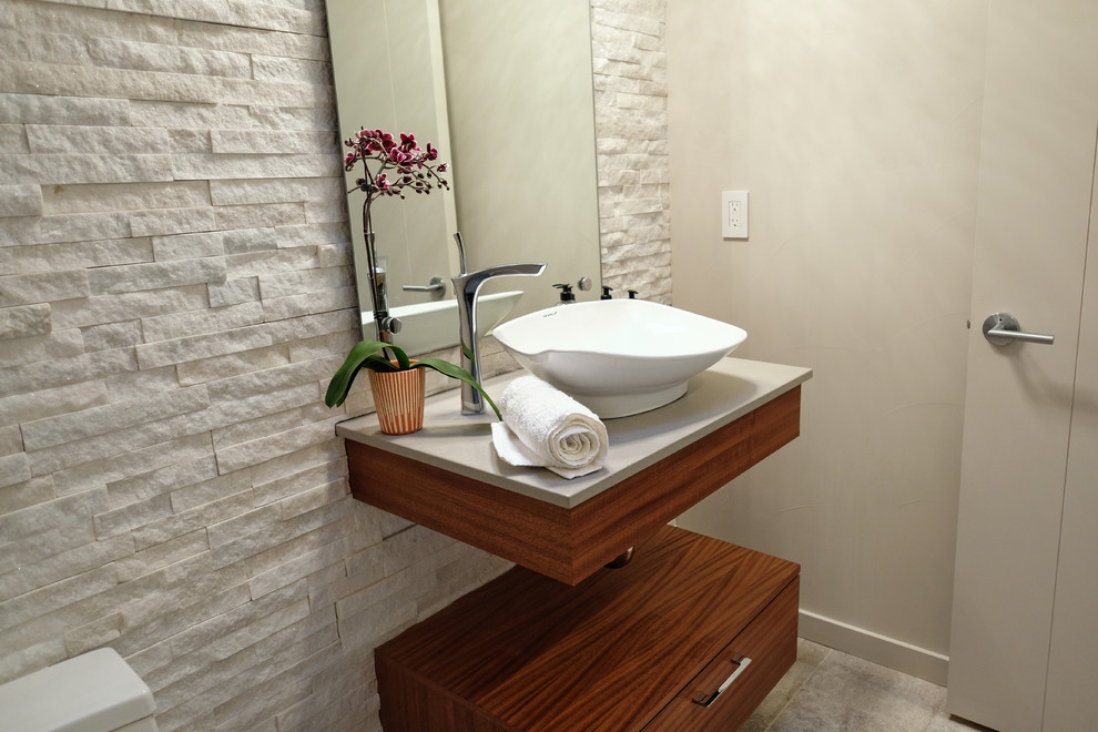 Foto på ett litet funkis beige toalett, med släta luckor, skåp i mellenmörkt trä, beige kakel, stenkakel, beige väggar, klinkergolv i porslin, ett fristående handfat och brunt golv