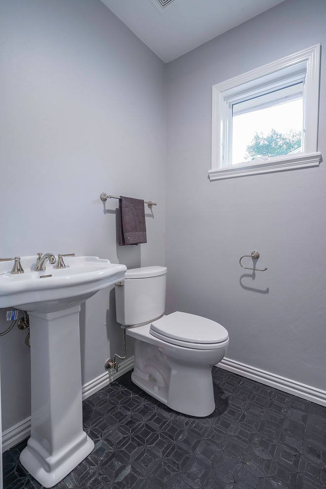 Inredning av ett modernt litet toalett, med en toalettstol med separat cisternkåpa, grå väggar, skiffergolv, ett piedestal handfat och svart golv
