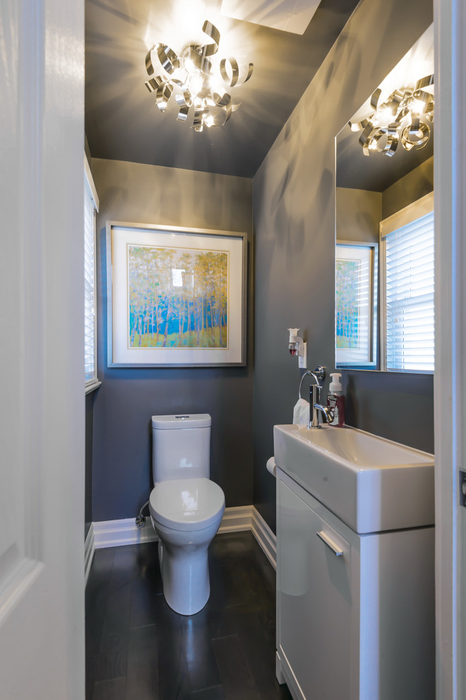 This is an example of a small classic cloakroom in Toronto with flat-panel cabinets, white cabinets, a one-piece toilet, grey walls, dark hardwood flooring and a trough sink.
