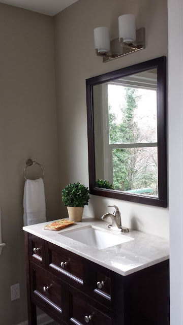 Diseño de aseo tradicional renovado, pequeño, con armarios tipo mueble, puertas de armario de madera en tonos medios, paredes grises, lavabo bajoencimera y encimera de cuarzo compacto