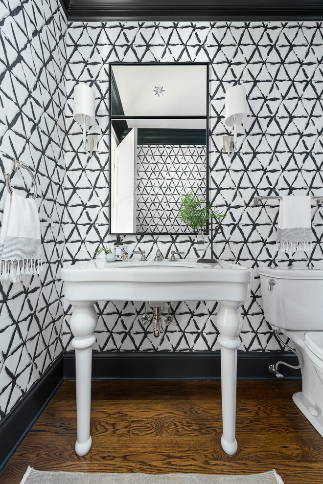 Exempel på ett klassiskt toalett, med en toalettstol med separat cisternkåpa, mellanmörkt trägolv, ett konsol handfat och brunt golv