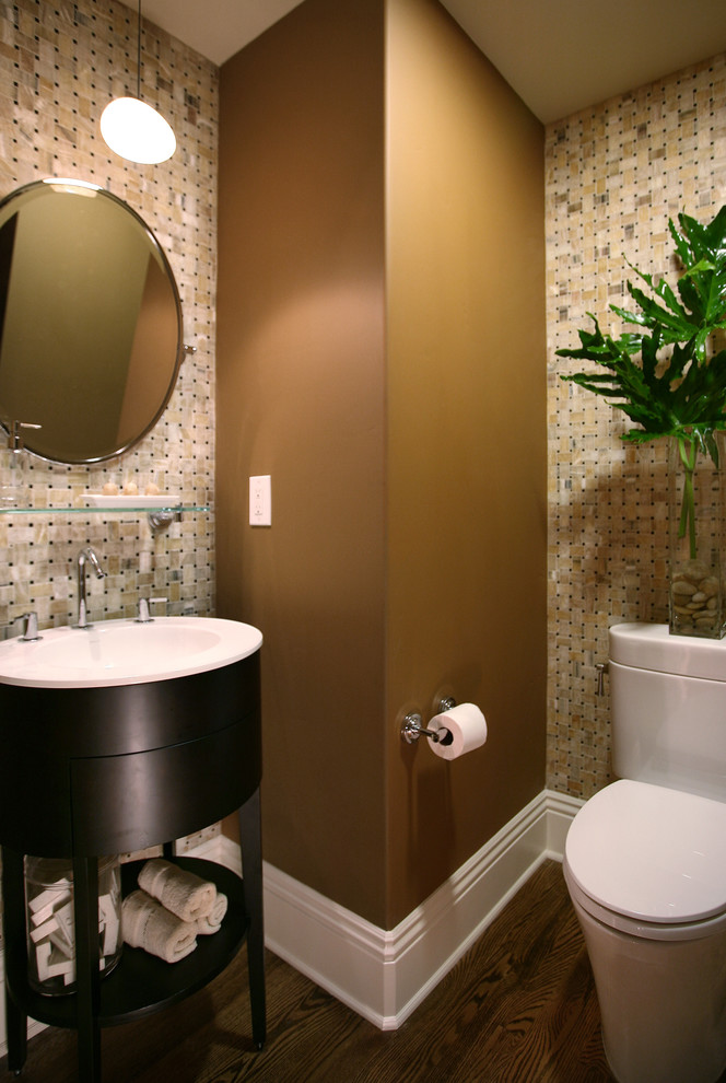 Foto på ett litet vintage toalett, med en toalettstol med hel cisternkåpa, beige kakel, stenkakel, bruna väggar, mörkt trägolv, ett integrerad handfat och brunt golv