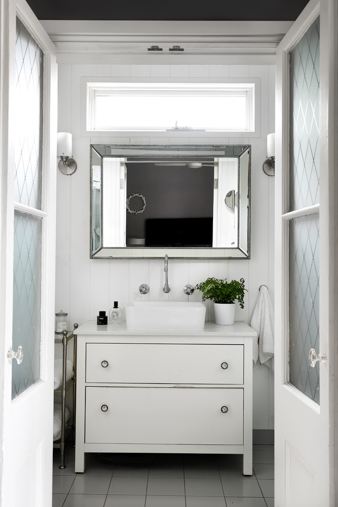 Cette image montre un petit WC et toilettes traditionnel avec un placard à porte shaker, des portes de placard blanches, un mur blanc, un sol en carrelage de céramique, un plan de toilette en marbre et un sol gris.