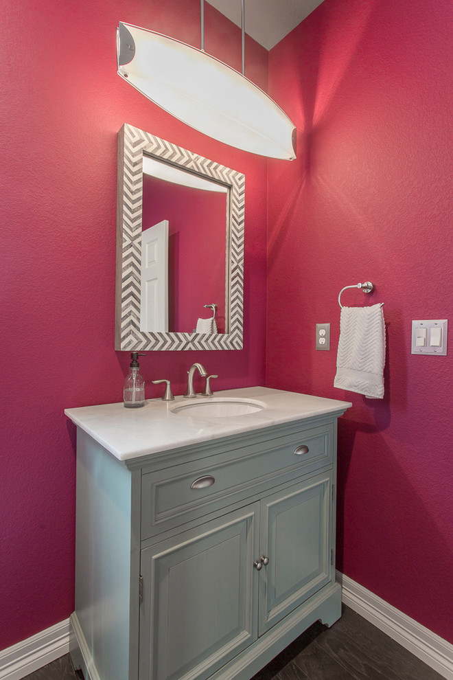Esempio di un piccolo bagno di servizio classico con ante con bugna sagomata, ante blu, WC monopezzo, pareti rosa, parquet scuro, lavabo sottopiano, top in marmo e pavimento marrone