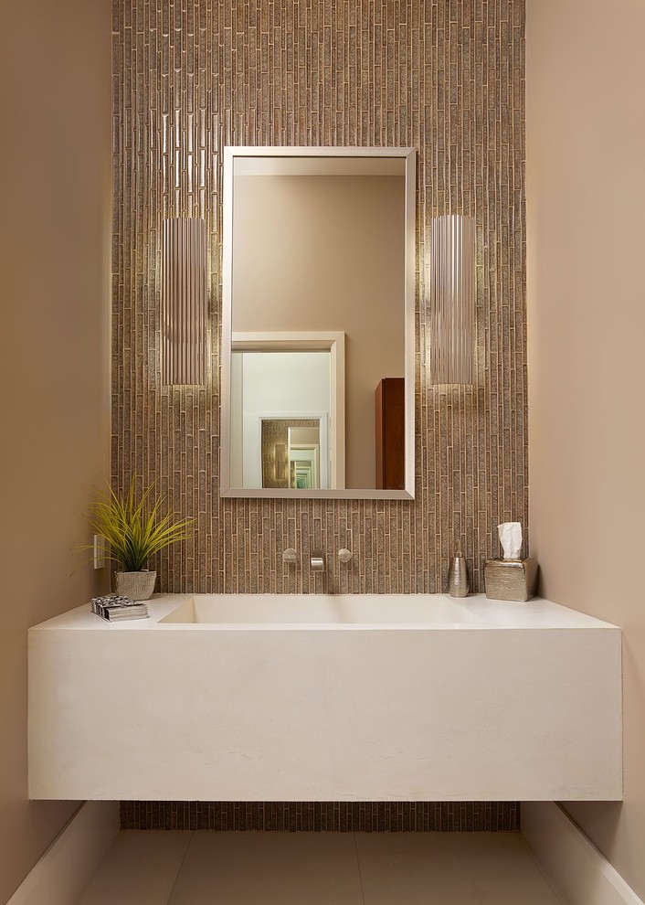 На фото: туалет в современном стиле с монолитной раковиной, бежевой плиткой и белой столешницей