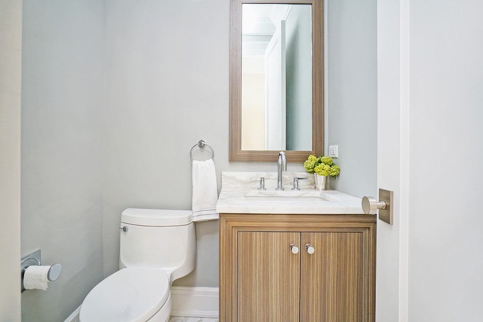 Design ideas for a small contemporary cloakroom in New York with flat-panel cabinets, light wood cabinets, a one-piece toilet, grey walls, marble flooring, a submerged sink, marble worktops, white floors and white worktops.