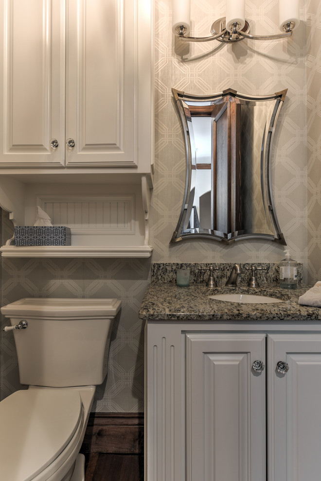 Inspiration for a medium sized traditional cloakroom in Oklahoma City with recessed-panel cabinets, white cabinets, a two-piece toilet, beige walls, dark hardwood flooring, a submerged sink, granite worktops and brown floors.