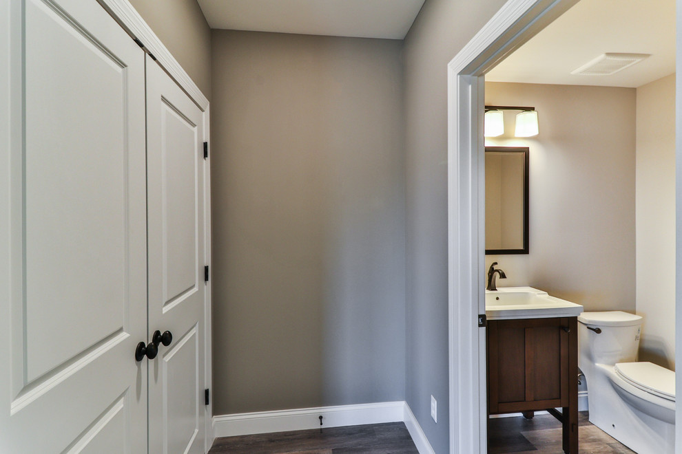 Design ideas for a medium sized traditional cloakroom in St Louis with shaker cabinets, brown cabinets, a two-piece toilet, beige walls, ceramic flooring, a submerged sink, engineered stone worktops and beige floors.