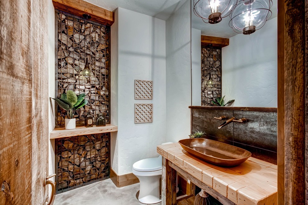 Foto på ett rustikt brun toalett, med öppna hyllor, vita väggar, ett fristående handfat, träbänkskiva och grått golv