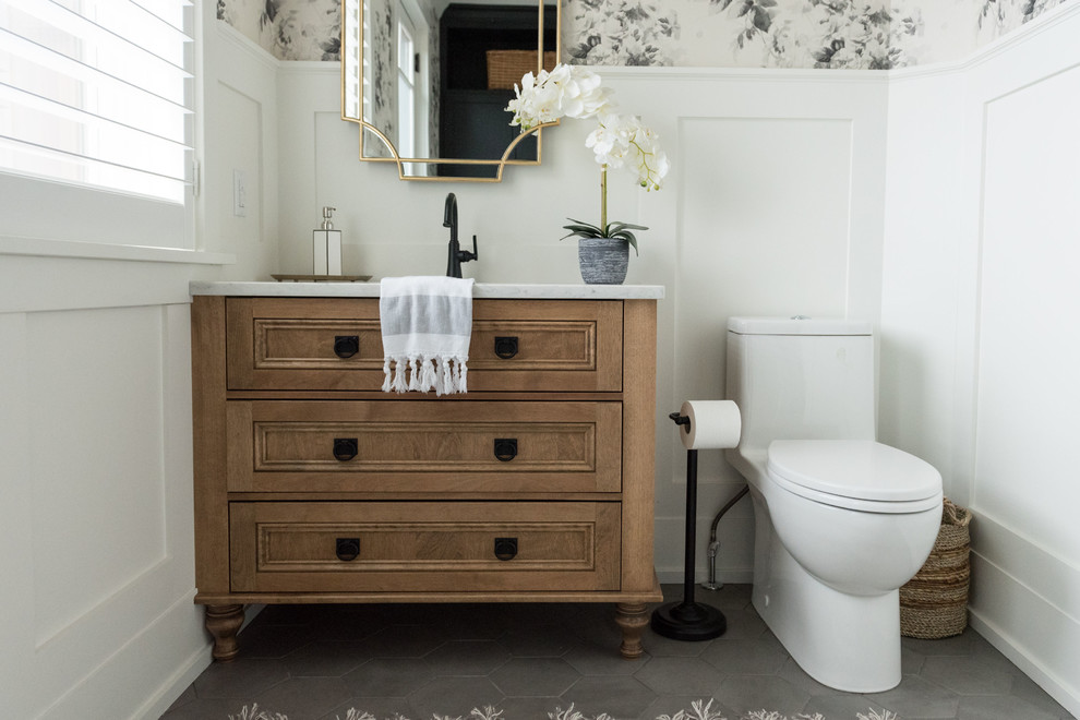 Cette image montre un WC et toilettes craftsman en bois brun de taille moyenne avec un placard en trompe-l'oeil, un sol en carrelage de porcelaine, un lavabo encastré, un plan de toilette en quartz modifié, un sol gris et un plan de toilette blanc.