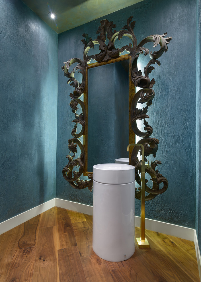 Idéer för att renovera ett funkis toalett, med ett piedestal handfat, blå väggar och mellanmörkt trägolv