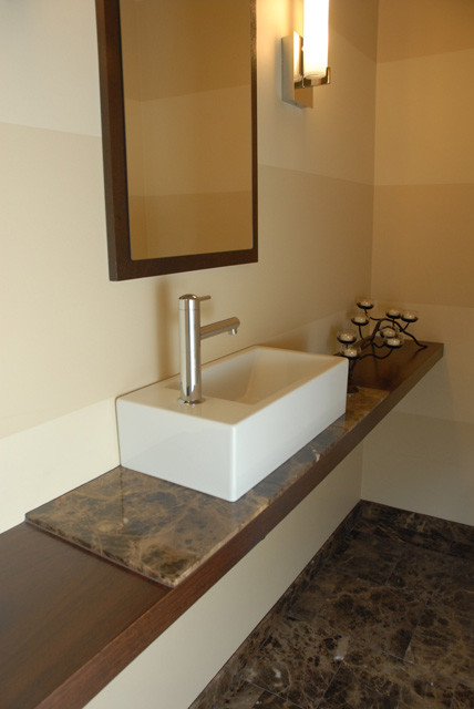 Cette image montre un petit WC et toilettes minimaliste en bois brun avec un sol en marbre.